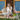 Linen Beige Florence Pant placed on a model sitting on the front porch of a blue and wood building