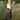 Long Dark Grey Linen Skirt with buttons on the front. It is on a model standing in a green field with a blurry background