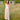 Long Beige Linen Skirt with buttons on the front. It is on a model standing in a green field with a blurry background
