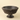 An antique dark brown ceramic pedestal bowl with a textured, beaded exterior