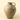 A handmade ceramic jug with a rounded body, a small handle, and a textured speckled glaze in earthy beige and brown tones, set against a solid cream background.