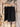 Tie Waist Linen Black Shorts on a hanger against a wooden wall background