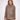 A woman modeling a brown and beige checkered blazer with solid brown sleeves, paired with a brown turtleneck and brown wide-leg trousers, against a plain white studio background.