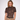 A woman modeling a short-sleeve leopard-print mock-neck top paired with high-waisted tan trousers and a black belt, photographed against a plain light gray studio background.
