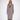 A woman modeling a long black and white houndstooth coat over a black top and dark brown pants, standing against a plain white studio background.
