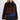 A woman modeling a cropped brown and black leopard-print faux fur jacket over a royal blue knit sweater and black trousers, shot against a light gray studio background.