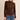 A woman modeling a brown long-sleeve mock neck top paired with blue jeans, standing against a plain beige studio background.